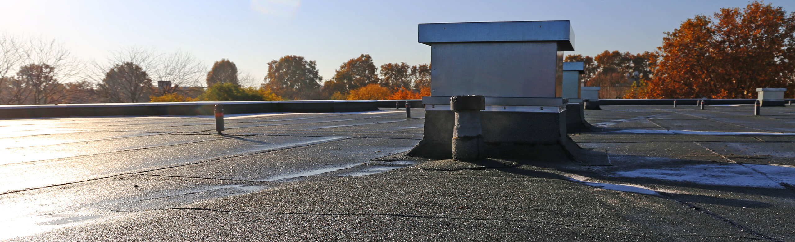 Construction – Lösungen für Flachdach und Abdichtung Flachdach mit Dachaufbauten und abgedichteten Anschlüssen im Herbstlicht